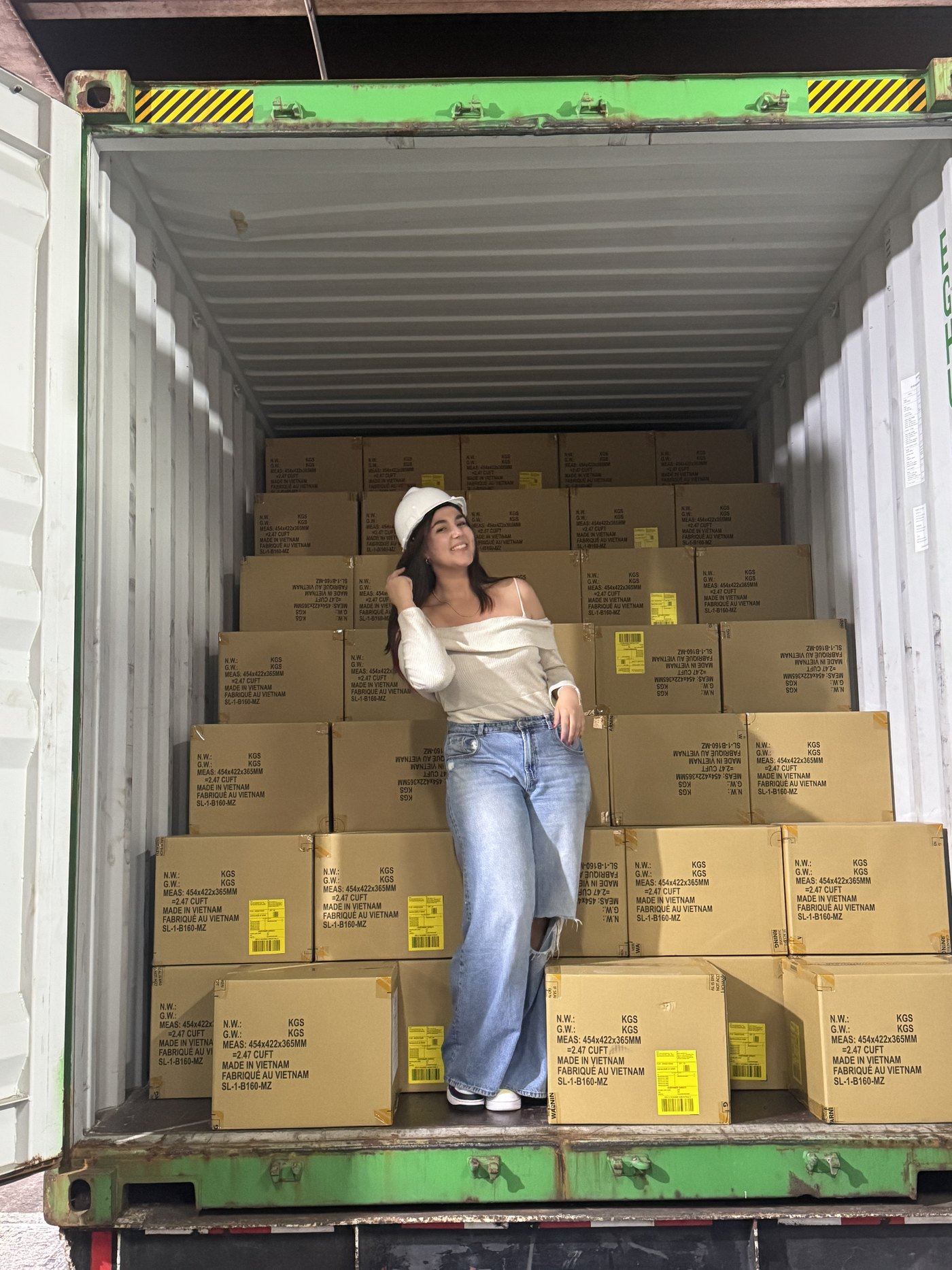 Valeria Bernardo dentro de un contenedor marítimo, junto a mercadería importada